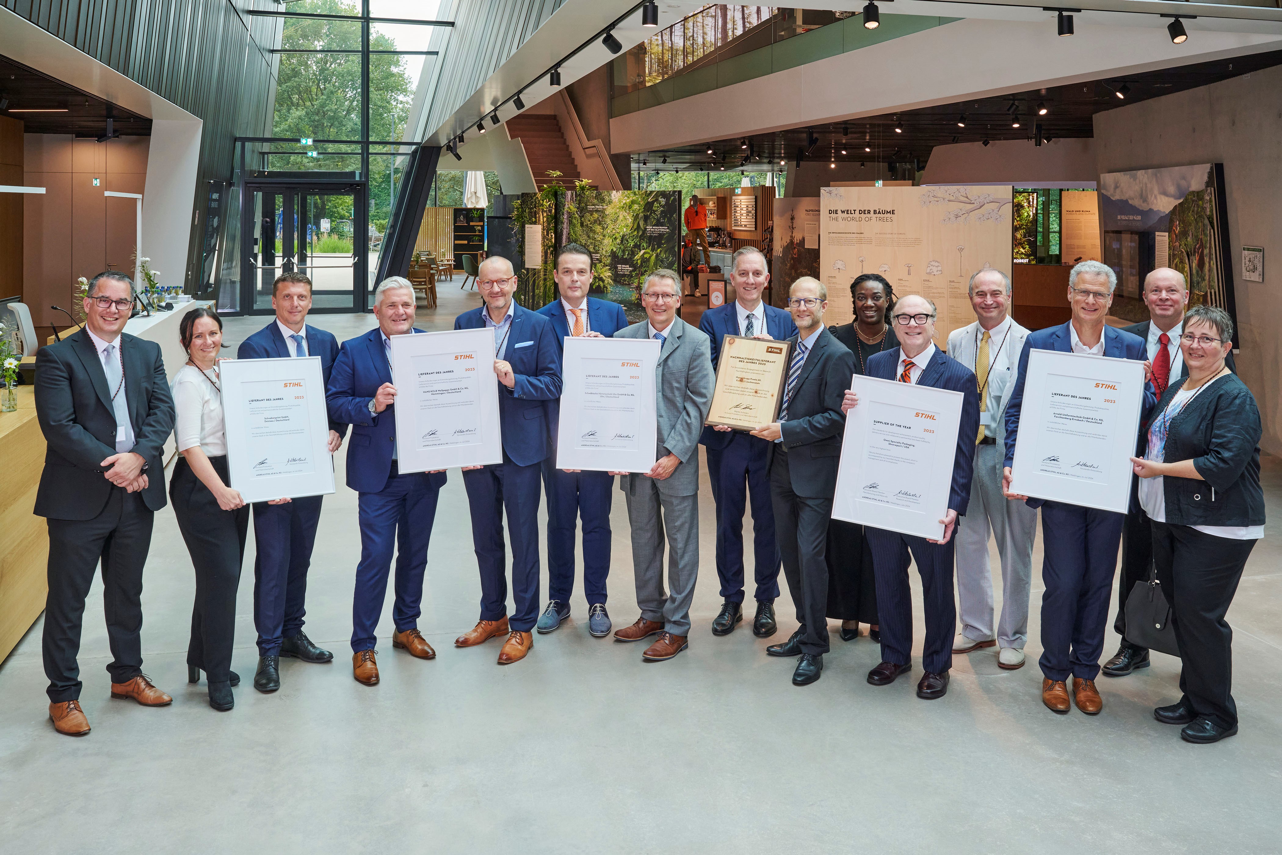Martin Schwarz, membru al consiliului executiv STIHL pentru producție și materiale (stânga), și Marc Moser, vicepreședinte pentru achiziții (spate dreapta), împreună cu furnizorii premiați în STIHL Brand World.